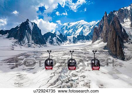 Stock Photography - Elevated view of three cable cars over snow covered valley at Mont blanc, France. Fotosearch