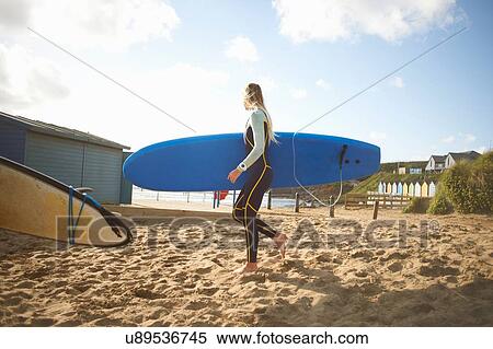Female surfer on beach, carrying surfboard View Large Photo Image Stock Photography - Female surfer on beach, carrying surfboard. Fotosearch