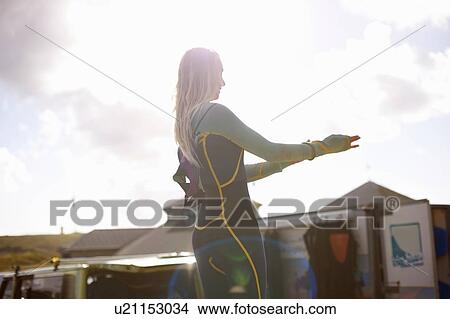 Female surfer putting on wetsuit View Large Photo Image Picture - Female surfer putting on wetsuit. Fotosearch