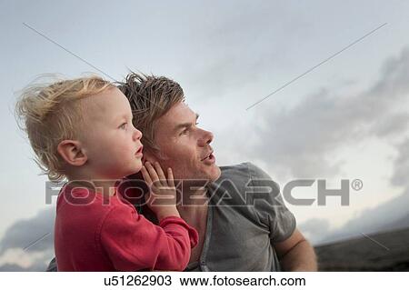 Stock Image - Female toddler and father looking up and watching. Fotosearch