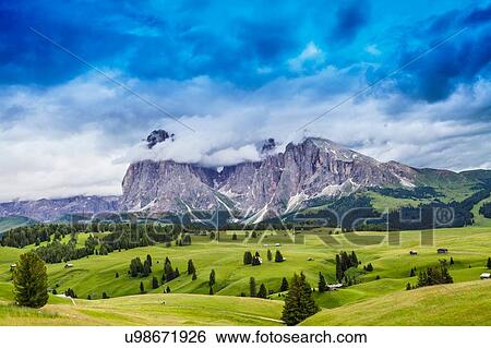 Fields and distant rock formation, Dolomites, Italy View Large Photo Image Stock Photograph - Fields and distant rock formation, Dolomites, Italy. Fotosearch