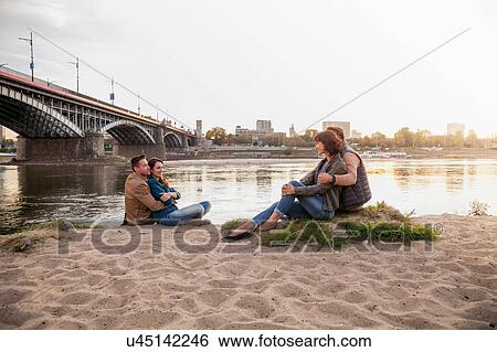 Four friends sitting on riverbank, Warsaw, Poland View Large Photo Image Stock Photograph - Four friends sitting on riverbank, Warsaw, Poland. Fotosearch