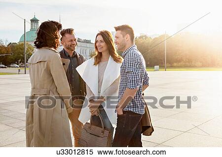 Stock Photography - Friends meeting in town square. Fotosearch