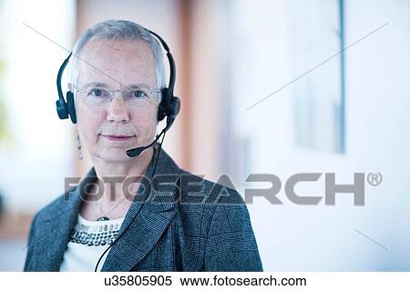 Front view of mature woman wearing telephone headset looking at camera View Large Photo Image Stock Photography - Front view of mature woman wearing telephone headset looking at camera. Fotosearch