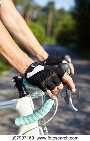 Stock Photo - Gloved-hands of cyclist on handle bar. Fotosearch