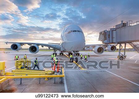Stock Image - Ground crew attending to A380 aircraft at airport. Fotosearch