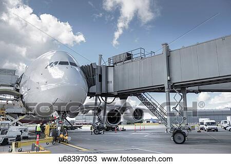 Stock Image - Ground crew inspecting A380 aircraft on stand in airport. Fotosearch