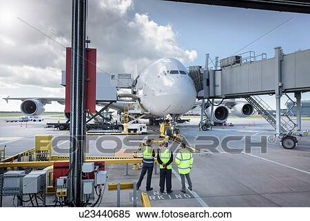 Stock Photography - Ground crew inspecting A380 aircraft on stand in airport. Fotosearch