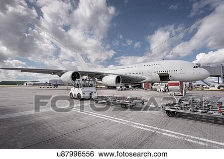 Stock Photograph - Ground crew loading A380 aircraft at airport. Fotosearch