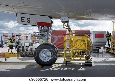 Stock Photograph - Ground crew loading luggage into A380 aircraft. Fotosearch