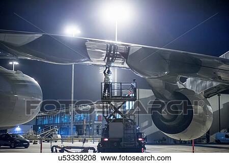 Ground crew member refuelling A380 aircraft at night View Large Photo Image Stock Photo - Ground crew member refuelling A380 aircraft at night. Fotosearch