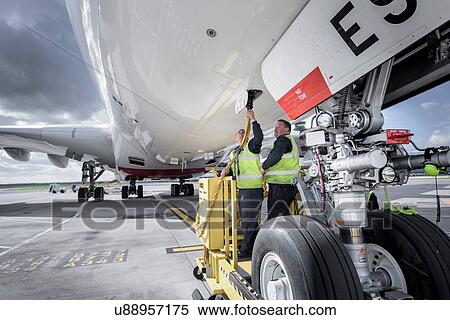 Stock Photography - Ground crew operating loading equipment on A380 aircraft. Fotosearch