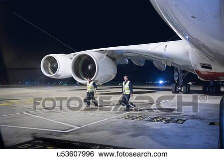 Ground crew removing wheel chocks from A380 aircraft at night View Large Photo Image Stock Photograph - Ground crew removing wheel chocks from A380 aircraft at night. Fotosearch