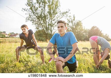 Group of friends exercising in field View Large Photo Image Stock Photo - Group of friends exercising in field. Fotosearch