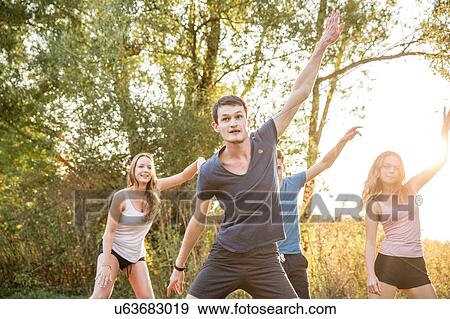 Stock Photo - Group of friends exercising in rural environment. Fotosearch