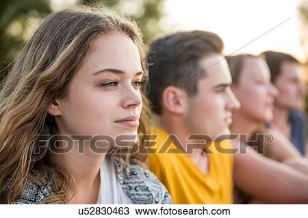 Stock Image - Group of friends outdoors, relaxing. Fotosearch