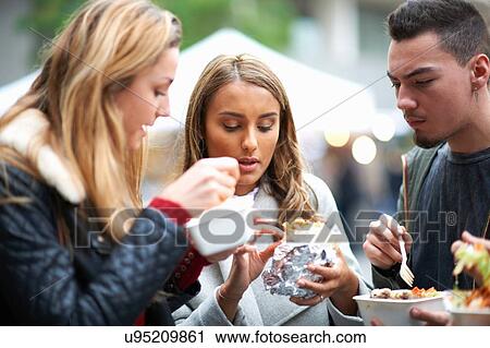 Group of young adults eating takeaway food, outdoors View Large Photo Image Stock Image - Group of young adults eating takeaway food, outdoors. Fotosearch