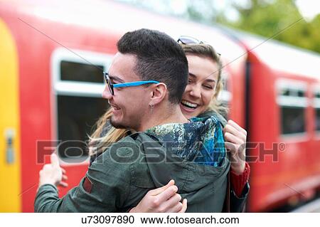 Heterosexual couple hugging at railway station, smiling View Large Photo Image Stock Image - Heterosexual couple hugging at railway station, smiling. Fotosearch
