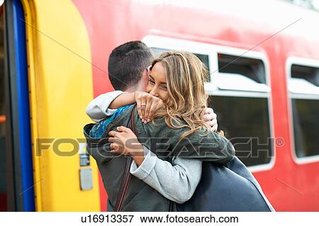 Heterosexual couple hugging at railway station View Large Photo Image Stock Photo - Heterosexual couple hugging at railway station. Fotosearch
