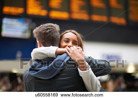 Heterosexual couple hugging at railway station, rear view View Large Photo Image Stock Photo - Heterosexual couple hugging at railway station, rear view. Fotosearch