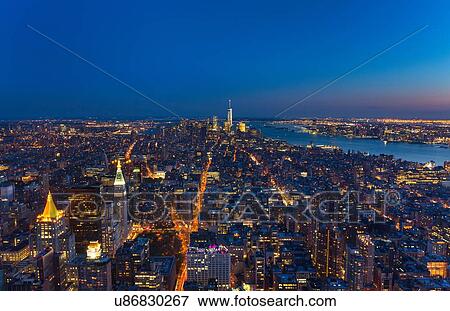 Stock Photo - High angle cityscape of Manhattan financial district and One World Trade Centre at dusk, New York, USA. Fotosearch