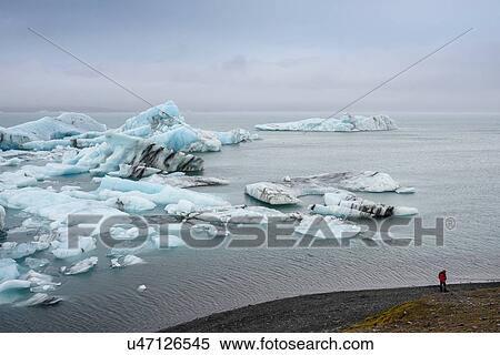 Hiker on iceberg coast, Jokulsarlon, Iceland View Large Photo Image Stock Photography - Hiker on iceberg coast, Jokulsarlon, Iceland. Fotosearch