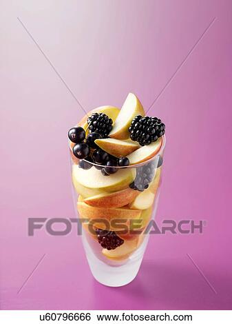 Stock Photograph - Ingredients in drinking glass for apple, blackcurrant and blackberry fruit juice. Fotosearch