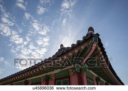 Stock Photograph - Low angle view of pagoda roof and cloudy blue sky, Korea, Seoul. Fotosearch
