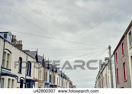 Stock Photo - Low angle view of terraced houses with telegraph pole and wires, Maryport, Cumbria, UK. Fotosearch