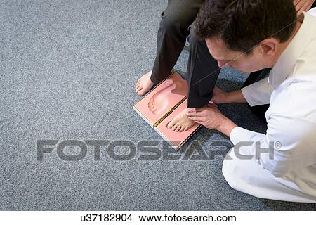 Picture - Making a foot imprint mould for orthopaedic foot support. Fotosearch