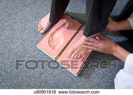 Stock Photo - Making a foot imprint mould for orthopaedic foot support. Fotosearch