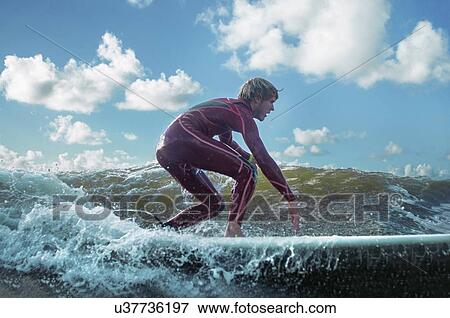 Stock Photo - Male surfer riding wave. Fotosearch