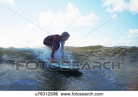 Stock Photo - Male surfer riding wave. Fotosearch
