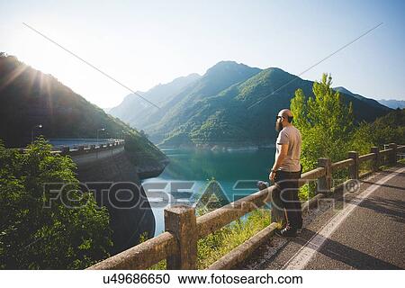 Stock Image - Man enjoying view of Lake Garda, Italy. Fotosearch