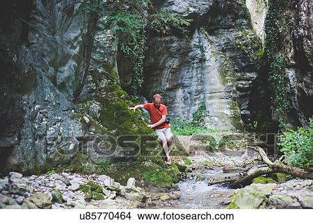 Picture - Man exploring rock formation, Garda, Italy. Fotosearch