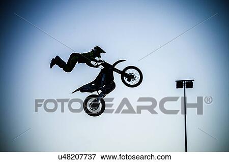 Man performing extreme stunt with motorcycle in mid air View Large Photo Image Stock Photo - Man performing extreme stunt with motorcycle in mid air. Fotosearch