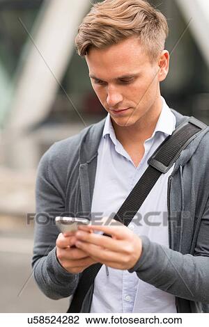 Stock Image - Man texting in street. Fotosearch