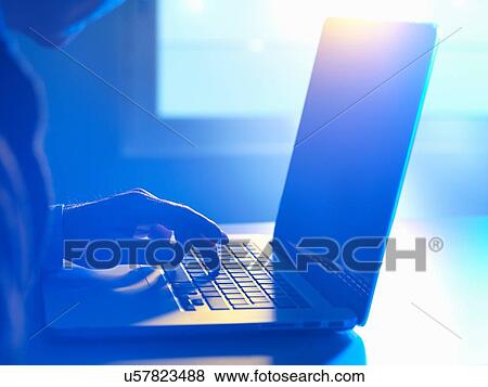 Stock Photo - Man typing at laptop computer. Fotosearch