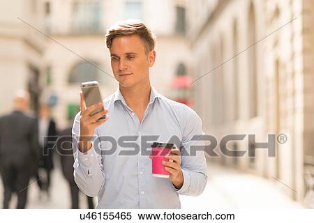 Man with takeaway coffee using smartphone View Large Photo Image Stock Photography - Man with takeaway coffee using smartphone. Fotosearch
