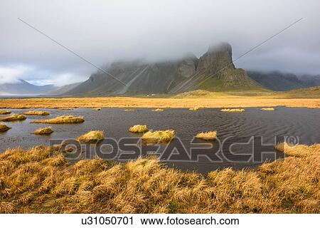 Stock Image - Marsh lake and mountains, Hvalnestangi, Iceland. Fotosearch