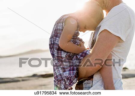 Mature man holding his toddler daughter on beach, Calvi, Corsica, France View Large Photo Image Picture - Mature man holding his toddler daughter on beach, Calvi, Corsica, France. Fotosearch