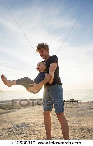 Mature man swinging his toddler daughter on beach, Calvi, Corsica, France View Large Photo Image Stock Image - Mature man swinging his toddler daughter on beach, Calvi, Corsica, France. Fotosearch