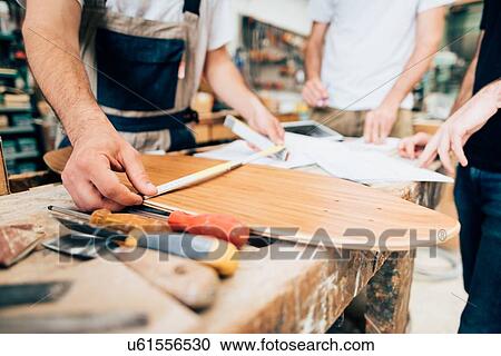 Stock Image - Measuring skateboard in workshop. Fotosearch