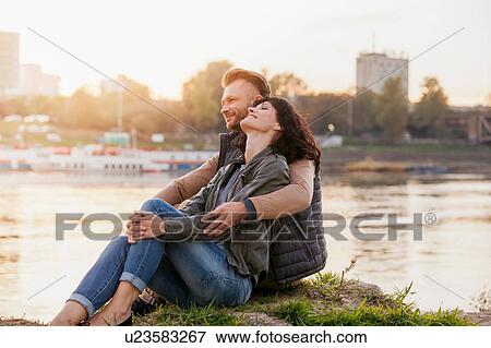 Mid adult couple sitting by river relaxing View Large Photo Image Stock Photo - Mid adult couple sitting by river relaxing. Fotosearch
