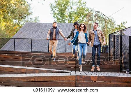 Mid adult couples holding hands on steps View Large Photo Image Stock Photo - Mid adult couples holding hands on steps. Fotosearch