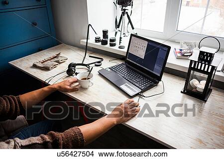 Mid adult man sitting at desk using laptop, mid section View Large Photo Image Picture - Mid adult man sitting at desk using laptop, mid section. Fotosearch