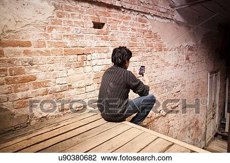 Mid adult man sitting on step using smartphone, rear view View Large Photo Image Stock Image - Mid adult man sitting on step using smartphone, rear view. Fotosearch