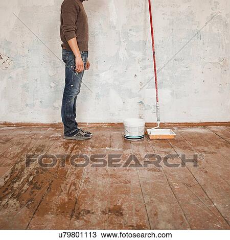 Mid adult man standing in room next to paint and paint roller, low section View Large Photo Image Stock Image - Mid adult man standing in room next to paint and paint roller, low section. Fotosearch