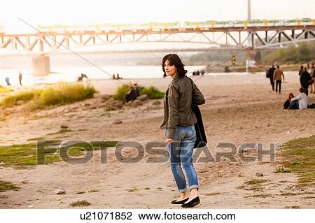 Mid adult woman looking over shoulder View Large Photo Image Stock Image - Mid adult woman looking over shoulder. Fotosearch