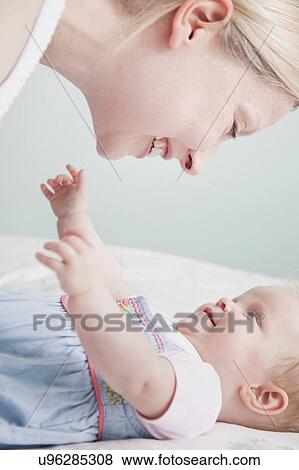 Mother and baby daughter face to face, laughing View Large Photo Image Stock Photo - Mother and baby daughter face to face, laughing. Fotosearch